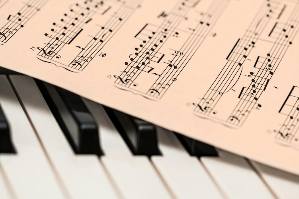 Black and white piano keys with a sheet of classical music creating a harmonious composition.